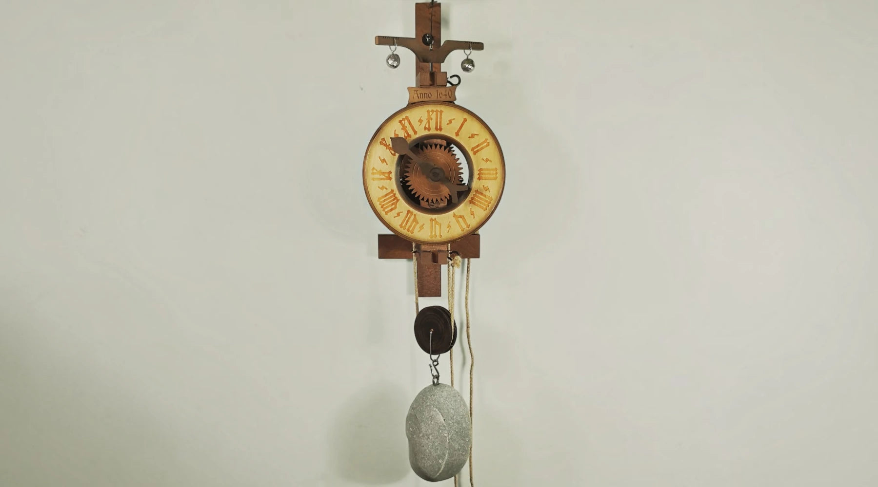 Rombach & Haas Hohenzollern wall clock with open wooden mechanism and stone weight