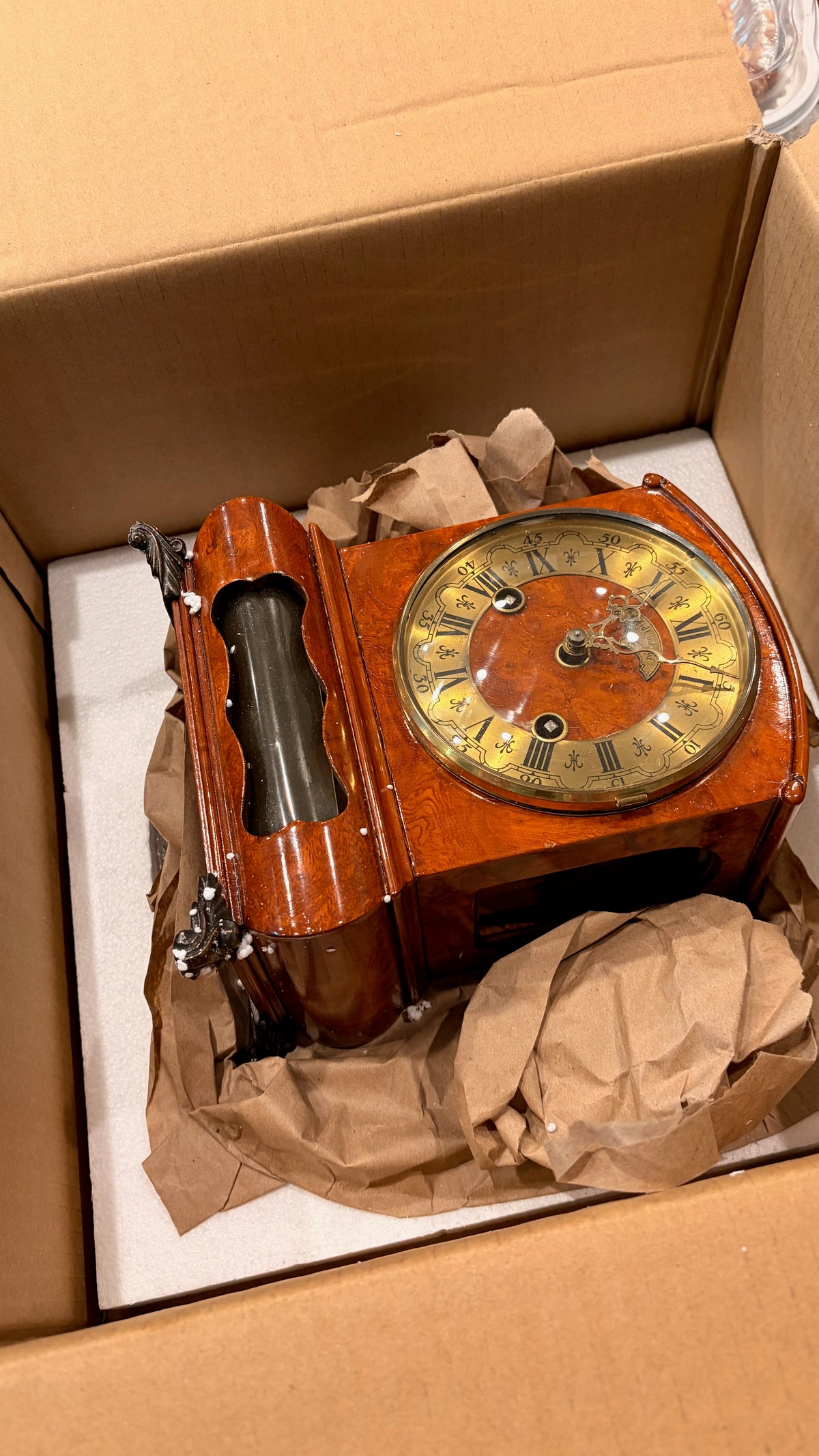 A Wuba mantel clock during packing, being prepared for shipping with protective materials.