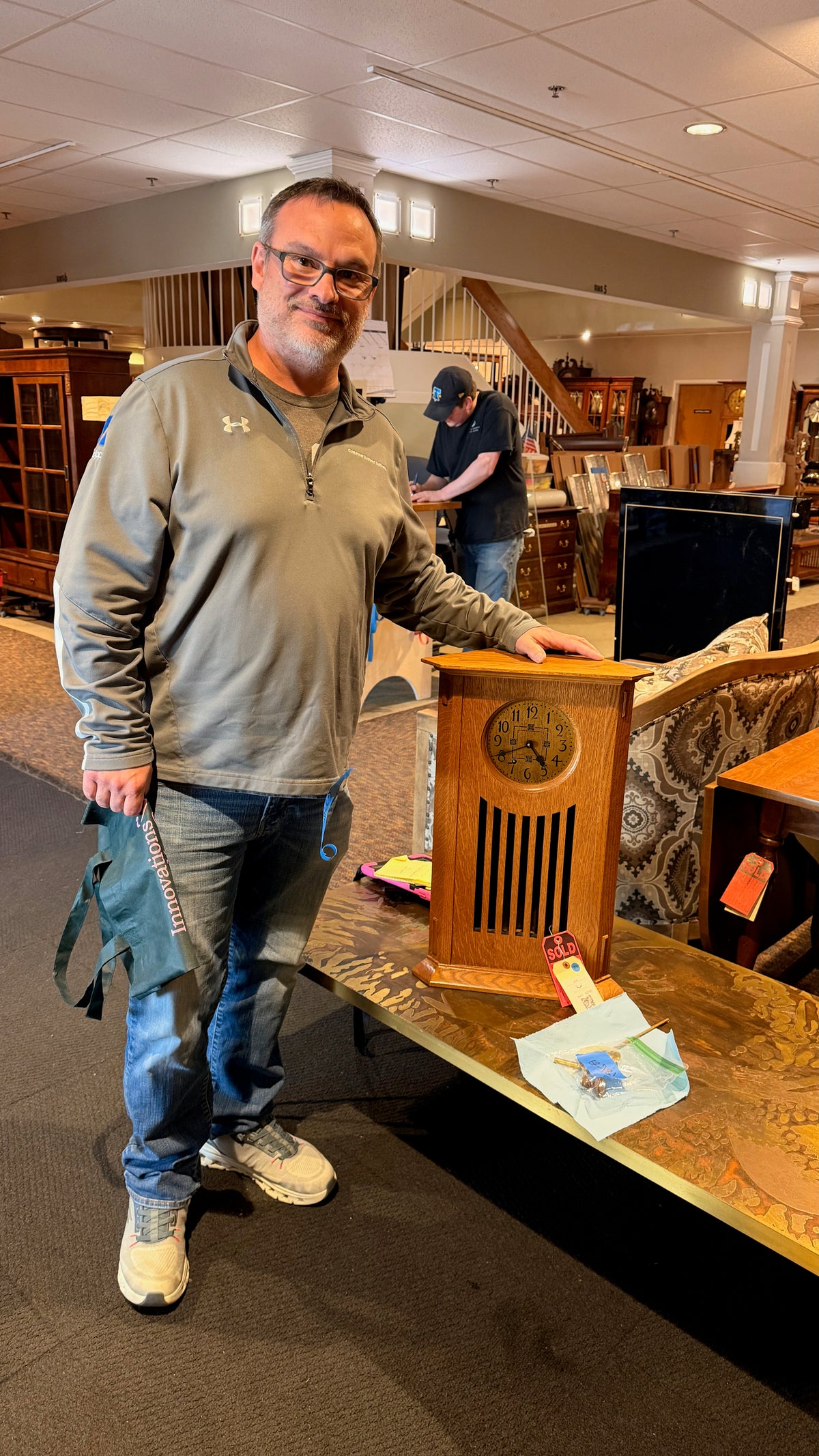 Andy Brooker beside a vintage Stickley clock he found while collecting.
