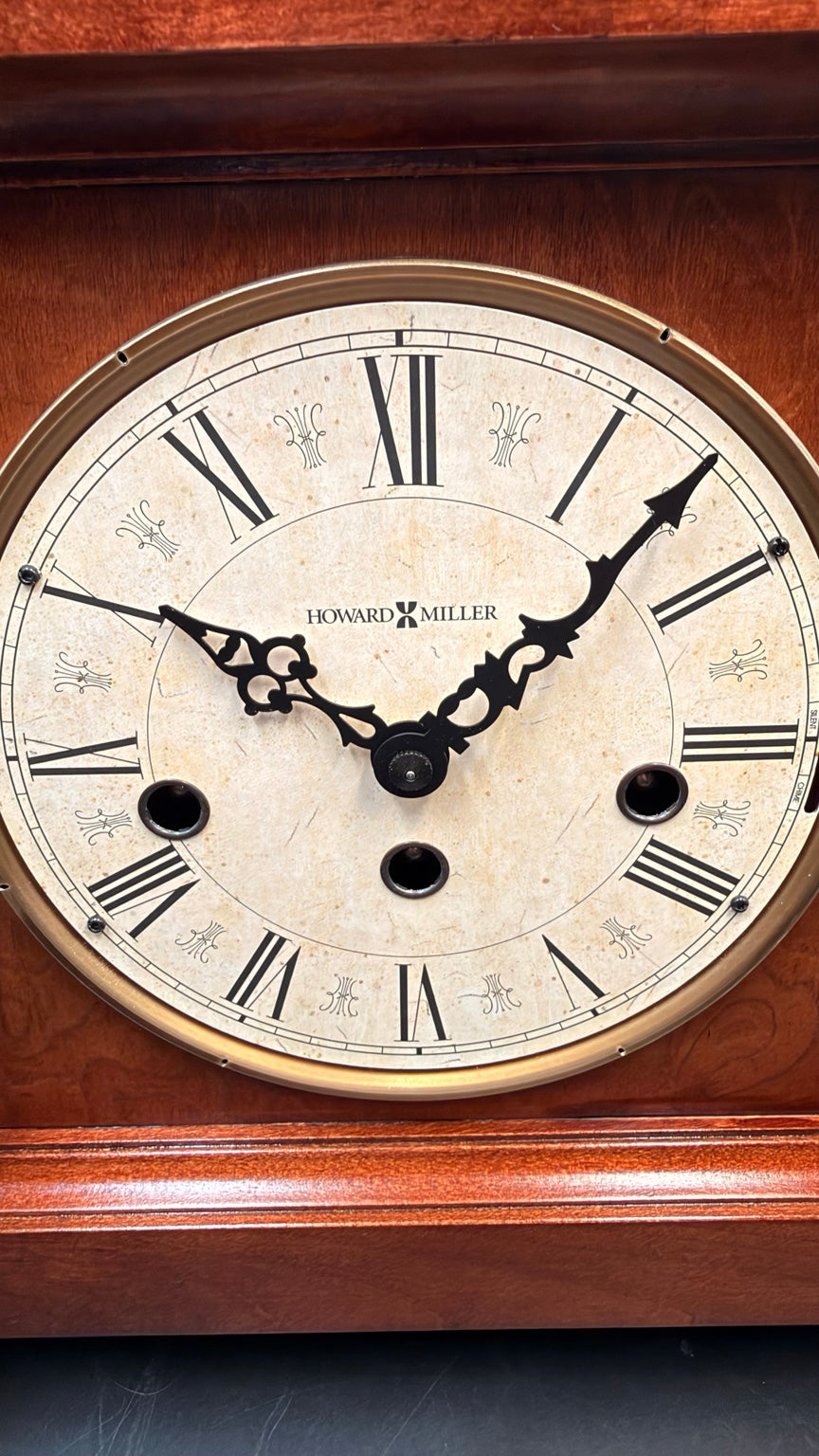 Close view of roman numerals, hands and winding arbors on Howard Miller Circa clock