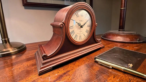 Pre-owned wood quartz mantel clock on a desk
